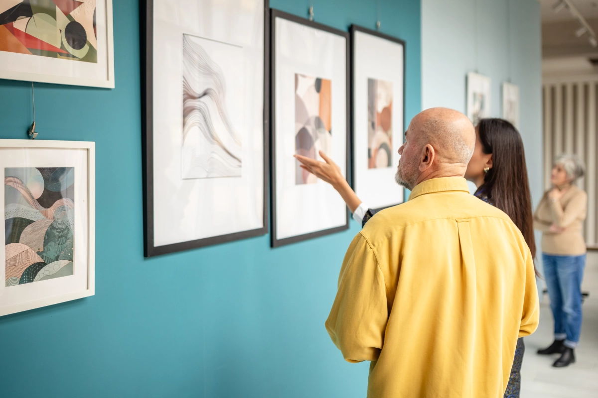 Art gallery visitors discussing framed paintings