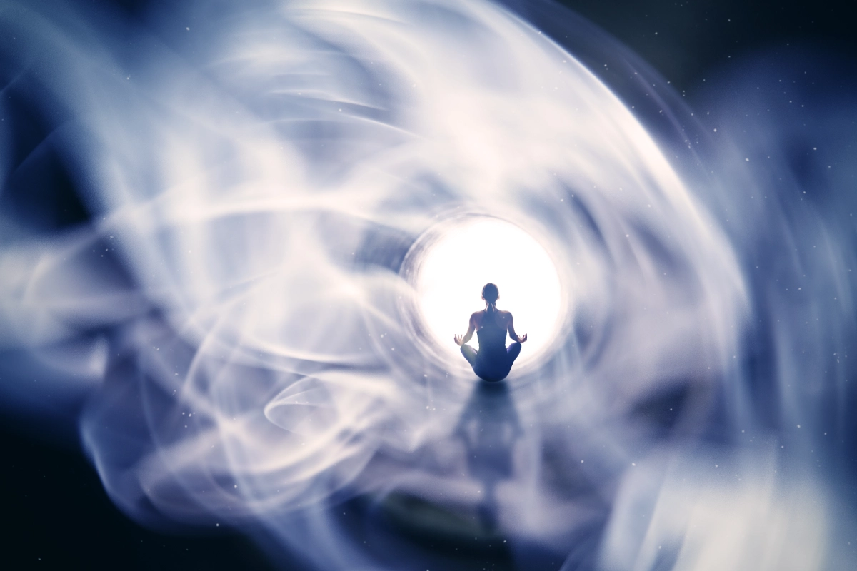 Meditating person surrounded by swirling light