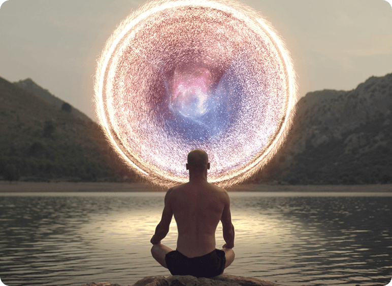 Person meditating before a glowing circular portal at dusk.